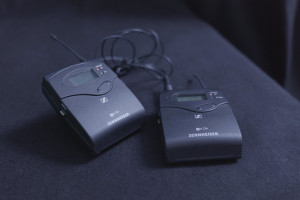 Funkstrecke bestehend aus Sender und Empfänger mit Ansteck-Mikrofon auf schwarzem Hintergrund